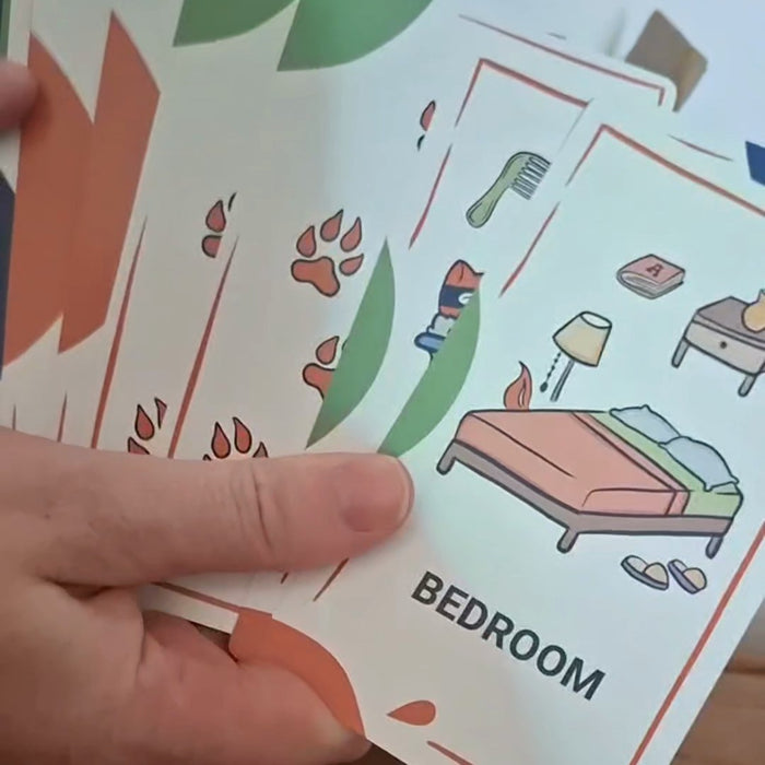 Hand holding the room clue cards, with the bedroom card on top