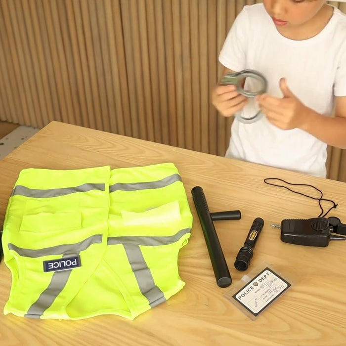 Police vest, baton, torch, walkie-talkie and ID card laid out on a table