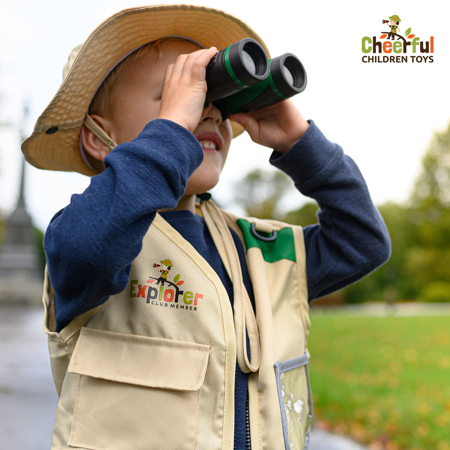 Boy in explorer vest and hat looking through binoculars