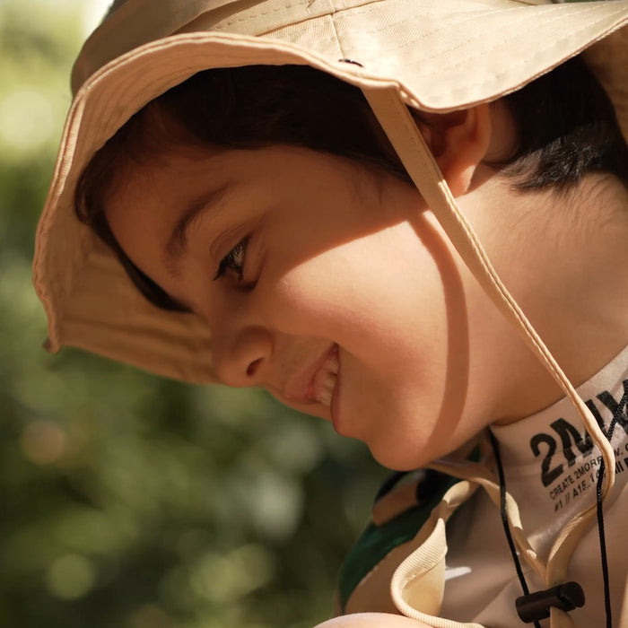 Boy smiling in the explorer hat