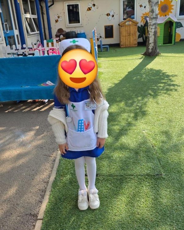 A girl at nursery in the full nurse set: cap, apron, badge and stethoscope