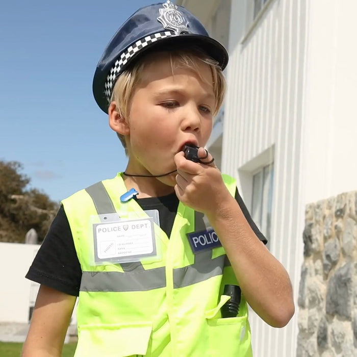 Boy in the police hat and hi-vis vest blowing the whistle